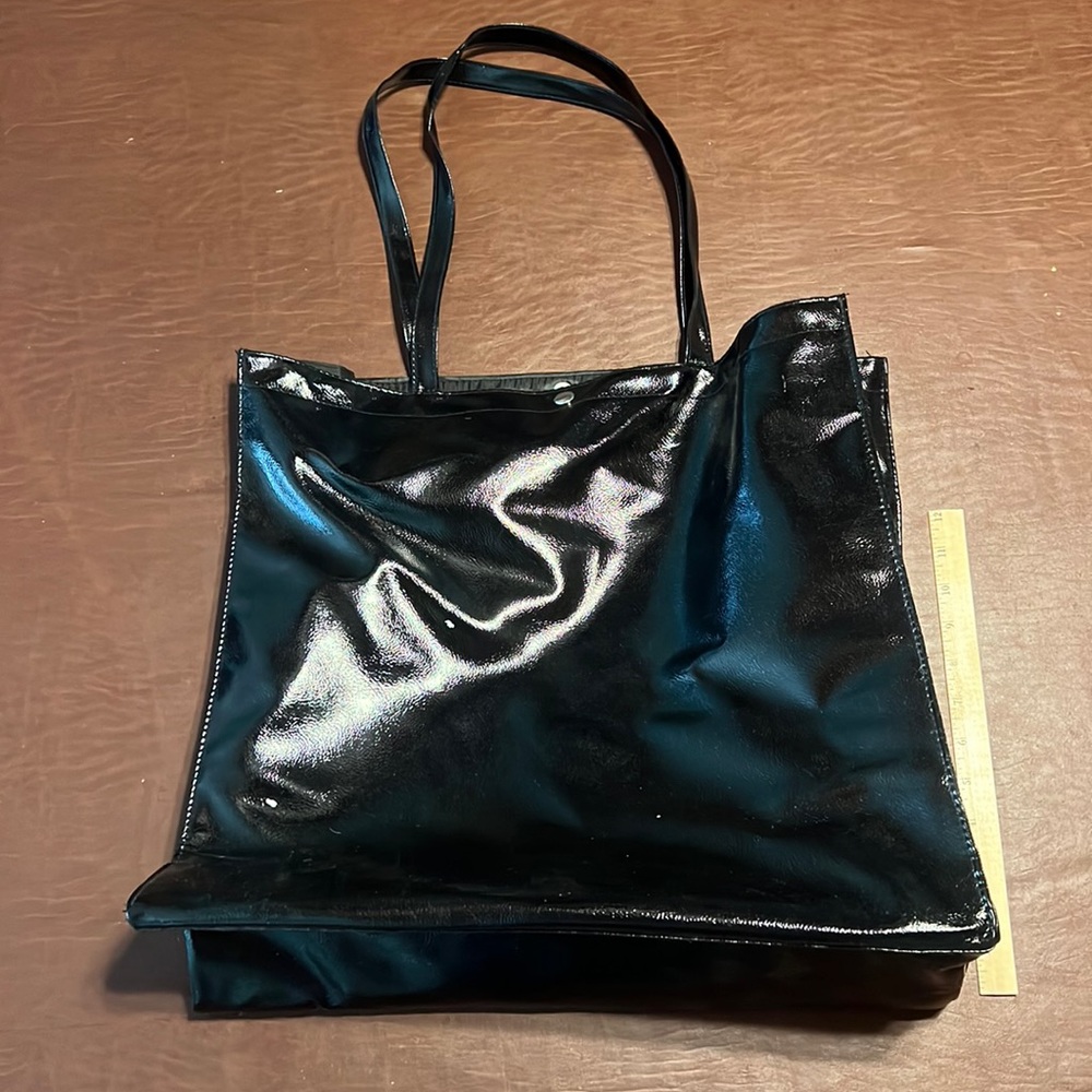 Free with purchase!! Large, black, faux leather tote with single snap closure.
